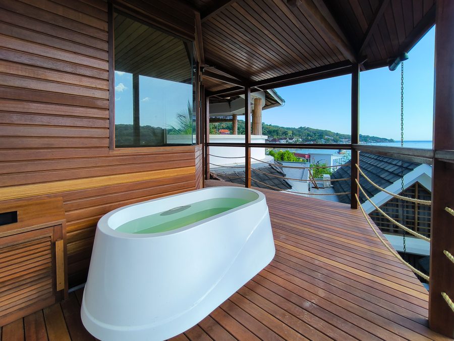 Freistehende Wanne auf der Holzterrasse mit Blick über Nusa Ceningan zum Meer